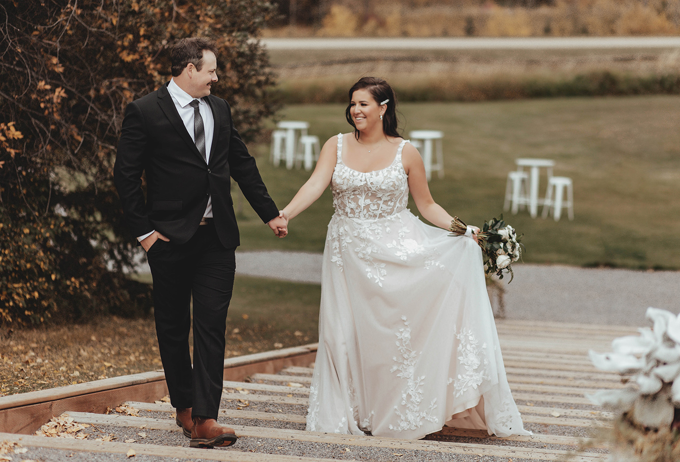 a man and woman holding hands and walking down stairs